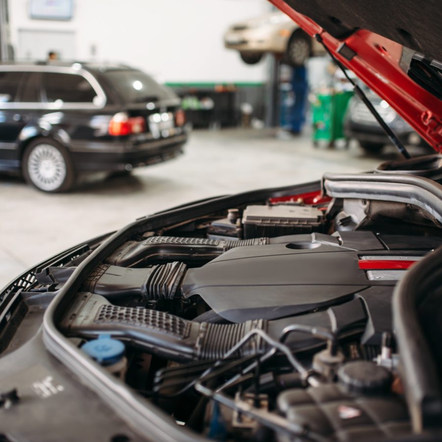 Car with opened hood in automobile service, motor diagnostic. Vehicle maintenance, auto-service